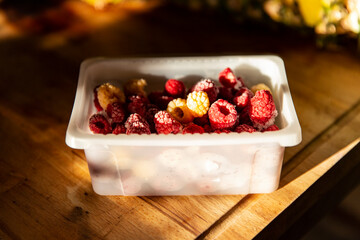Frozen red and yellow raspberry berries in a box
