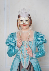 Beautiful young woman in medieval style dress with mask