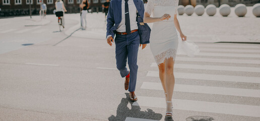 Stylish bride and groom walking together in downtown