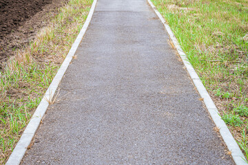 Asphalt footpath in countryside. Limited depth of field.
