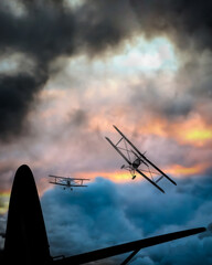 3D Illustration. Looking back over the tail of the lead  double wing biplane as two other vintage airplanes follow. © Bob Orsillo