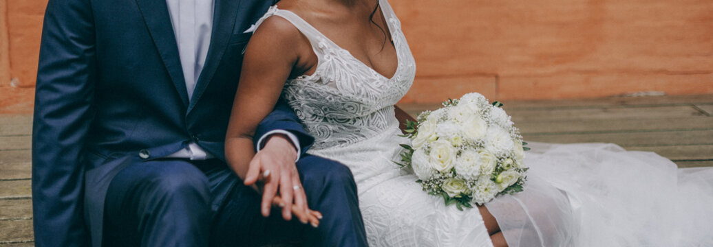Afro-american bride and caucasian groom posing on a wedding photo shoot
