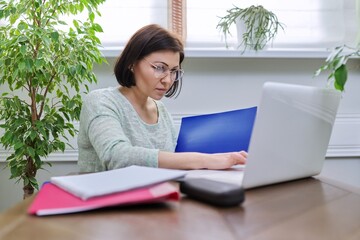 Business woman working at home online using laptop.
