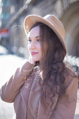 Portrait of pretty woman with curly hair in pastel pink coat portrait