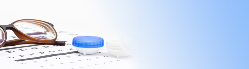 Contact lenses case and eye glasses on and eye test chart. Vision concept. Way to improve vision