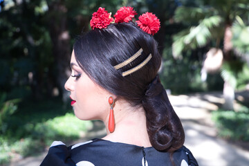 Detail of hairstyle, earrings, of young woman flamenco artist, brunette, with typical black...