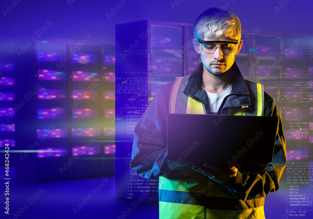Poster an engineer next to servers. male network administrator. network administrator career. data center e