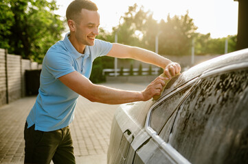 Man using sponge with foam, hand car wash