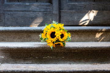 Beautiful sunflower bouquet centred on cement stairs with vintage doors background