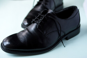 Close up of some fancy black bright shoes on a green surface 