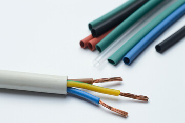 heat shrink tubing and a three-core stripped wire on a white background.