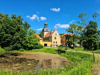 Beautiful Latvian Lielstraupe castle among green trees on a sunny summer day in 2021