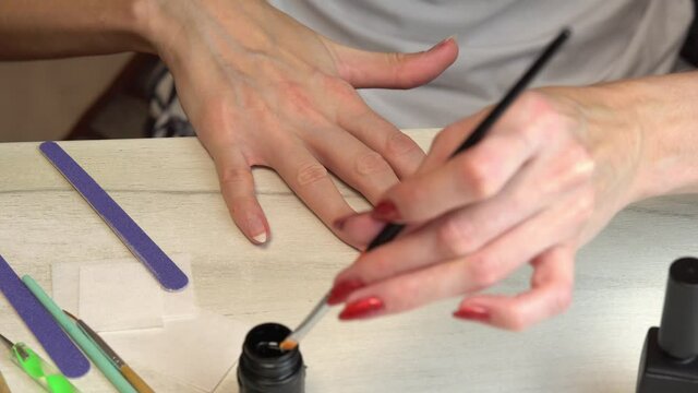 Applying a base coat before coating nails with nail polish, self manicure at home
