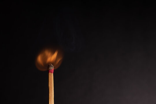 A match being lit and consumed by fire.
