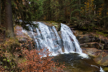 Fototapeta na wymiar small waterfall on a river in czech mountains