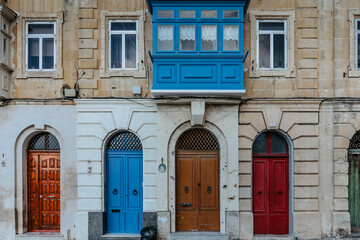 Fototapeta na wymiar Traditional colorful Maltese doors in Valletta.Front doors to houses from Malta.Blue red brown doors and wooden balcony.Maltese vintage apartment building.Popular travel destination.Entrance to house