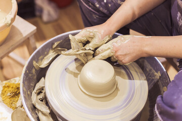Pottery workshop. Closeup of woman artist hands molding clay on pottery wheel. Creative handmade craft. Ceramic art studio.