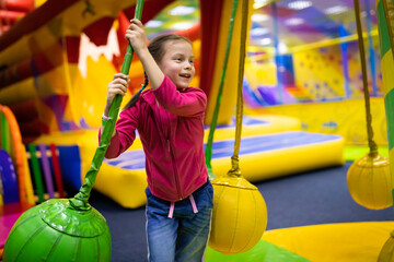 Little smiling girl having fun in amusement center for kids