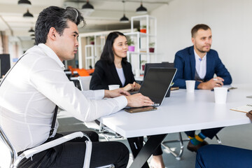 Group of young business people working and communicating while sitting at the office desk together with colleagues sitting. business meeting