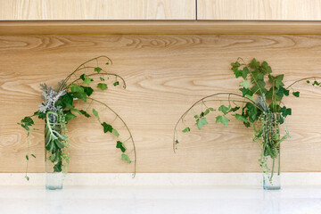 Kitchen interior , Two glass vases with beautiful flowers on the kitchen cabinets