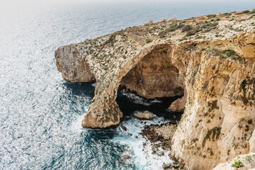 Aerial view of magnificent Blue Grotto,complex of seven caves found along southern coast of Malta.Popular diving and snorkelling spot.Clear, bright blue waters.Rocky limestone arch.Maltese nature