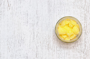 Fototapeta na wymiar Ghee in a glass jar, top view. Melted butter. Place for your text.