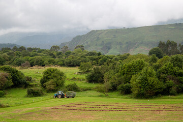 Tractor working the field next to the mountains