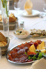 Spread of prosciutto, salami and cheese, served on a festive table. Selective focus.