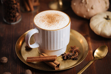 A cup of pumpkin spice latte or salep in a rustic wooden autumn atmosphere