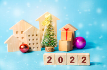 Wooden blocks 2022, Christmas tree and miniature houses. New Year or Xmas winter holiday....