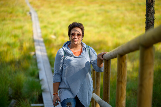 An Athletic, Middle-aged Woman, 50 Years Old, Hikes In Nature, Has An Active And Mobile Lifestyle. Climbs The Stairs Briskly.