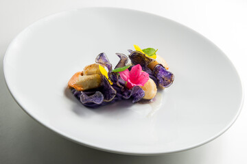 Scallops on purple mashed potatoes and colorful flowers