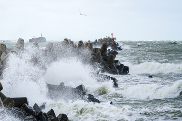 Fototapeta na wymiar during stormy weather, large waves crash against the concrete blocks of a breakwater