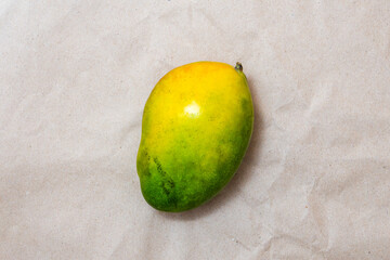 Ripe green and yellow mango fruit on brown craft paper. Top view