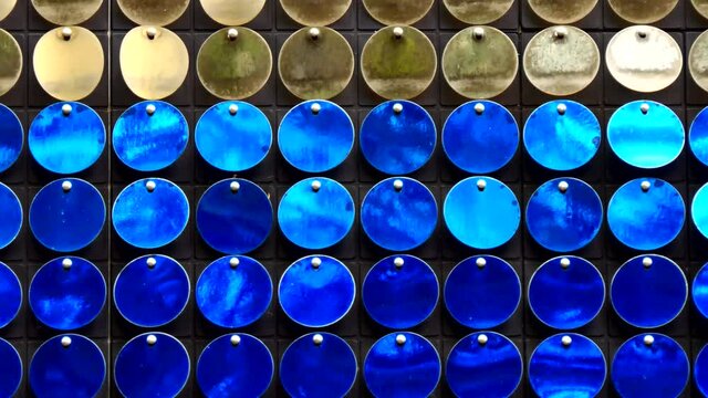 Abstract many blue and white sequin circles shivering on black background.