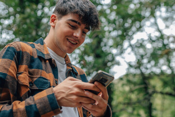 adolescent male with mobile phone in autumn outdoors