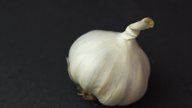 Garlic spinning on black background, close shot of an garlic solwly rotating on a black background