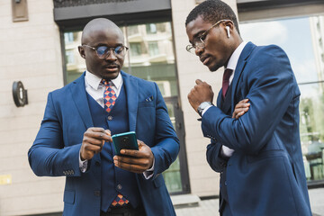 Meeting of two partners black african american businessman in suits and glasses outdoors