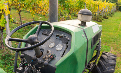 Vintage: Detail of green tractor in front of luminous vineyard