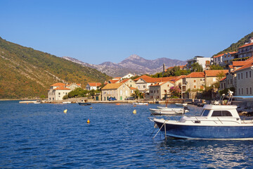 Fototapeta na wymiar Beautiful autumn Mediterranean landscape. Seaside village on cost of bay. Montenegro, Adriatic Sea. View of Kotor Bay and Lepetane village (Tivat)