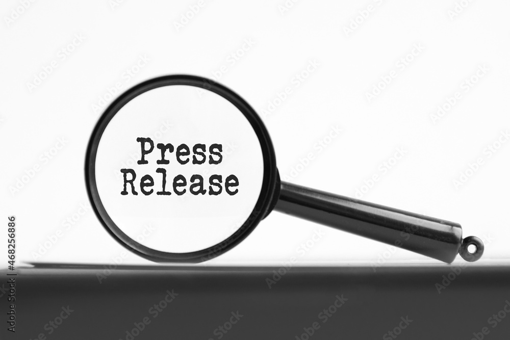 Poster magnifying glass with text press release on notebook