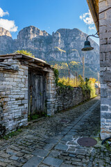 view of traditional architecture  with   stone buildings and background astraka mountain during  fall season in the picturesque village of papigo , zagori Greece