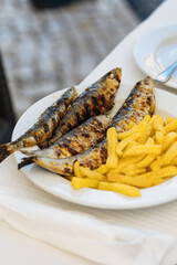 Grilled sardines with french fries served for lunch