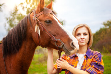 Beautiful young blond woman with a horse, portrait.