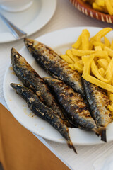 Grilled sardines with french fries served for lunch