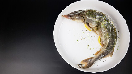 sturgeon fish on a white plate on a black background. cooking expensive beluga