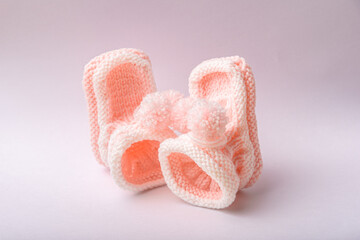 homemade knitted shoes for newborn girl on white background