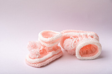 homemade knitted shoes for newborn girl on white background