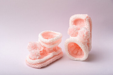 homemade knitted shoes for newborn girl on white background
