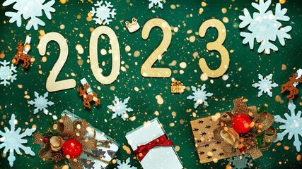 Christmas composition made of Christmas decoration and 2022 numbers on Green background. Minimal concept of Xmas and New Year